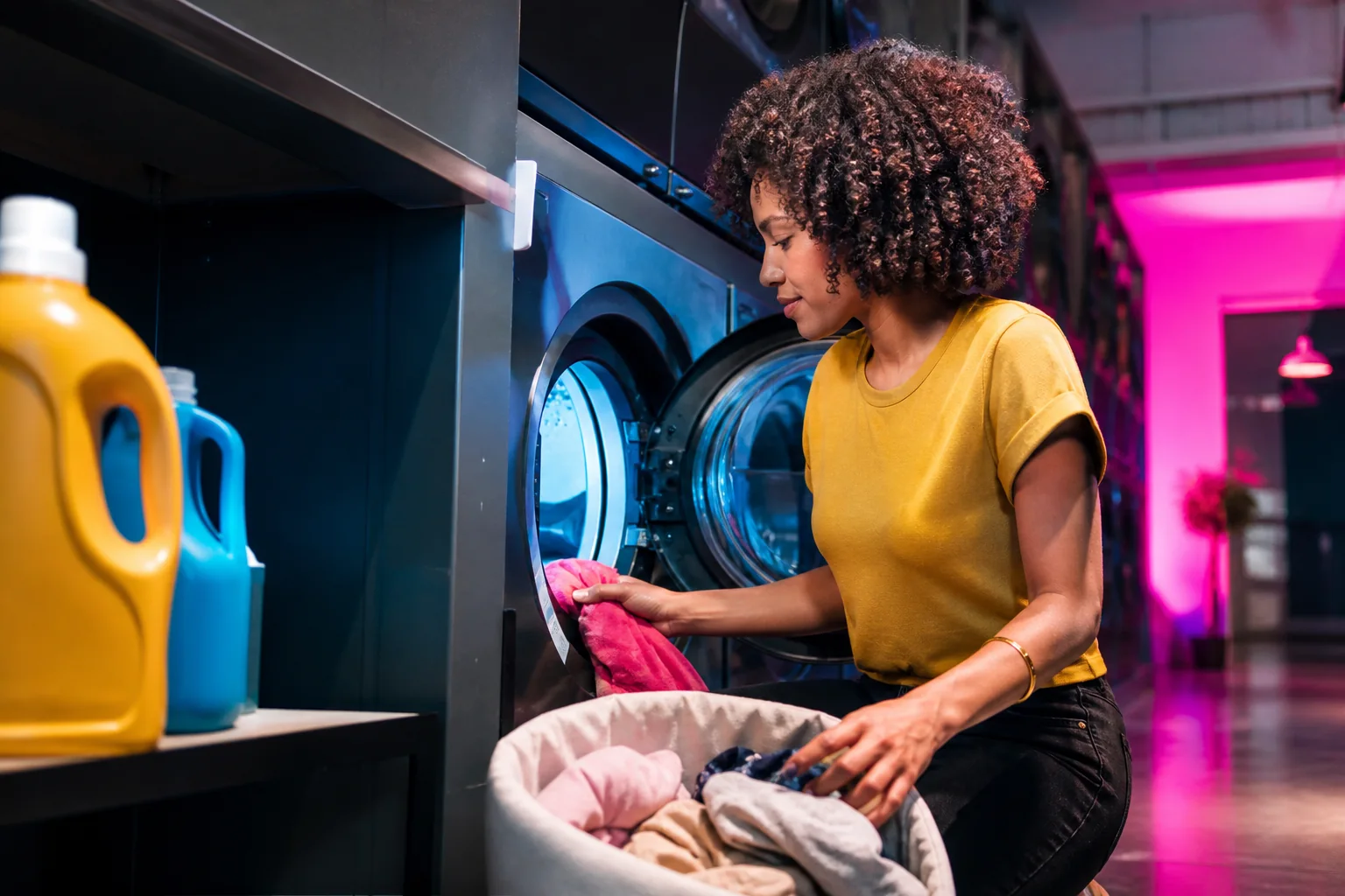 Customer loading her own laundry into a commercial washer